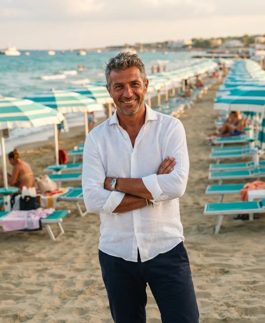 Marco Rinaldi in spiaggia davanti alle file di ombrelloni del suo lido